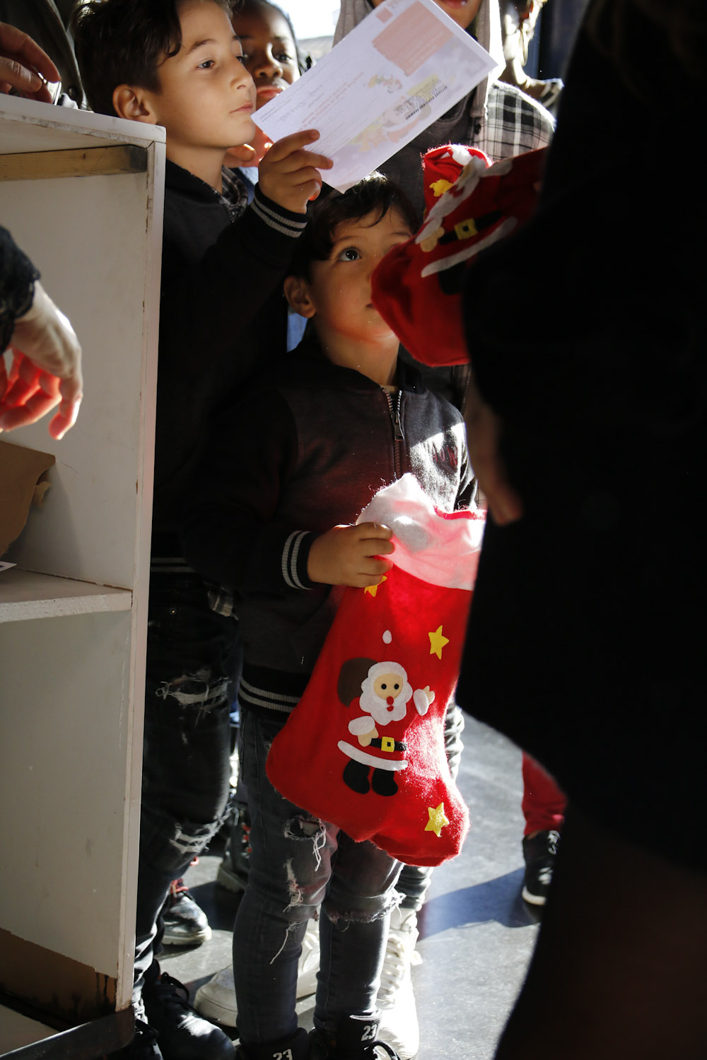 enfant reçoit une chaussette de Noël remplie de friandises