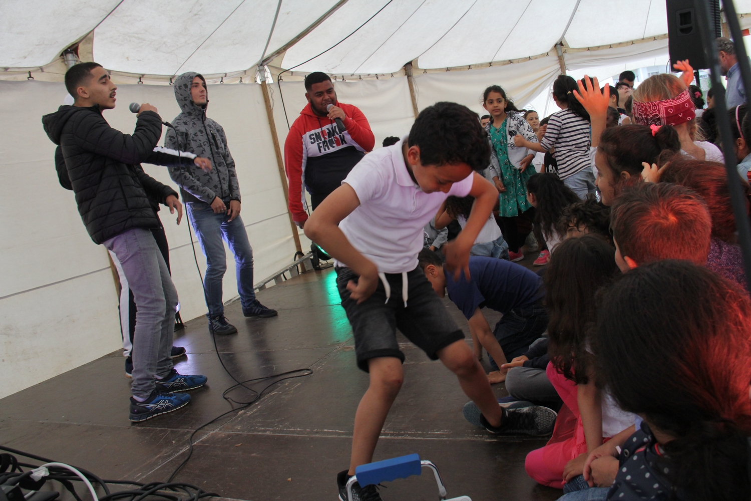 Les enfants dansent sur scène avec les rappeurs